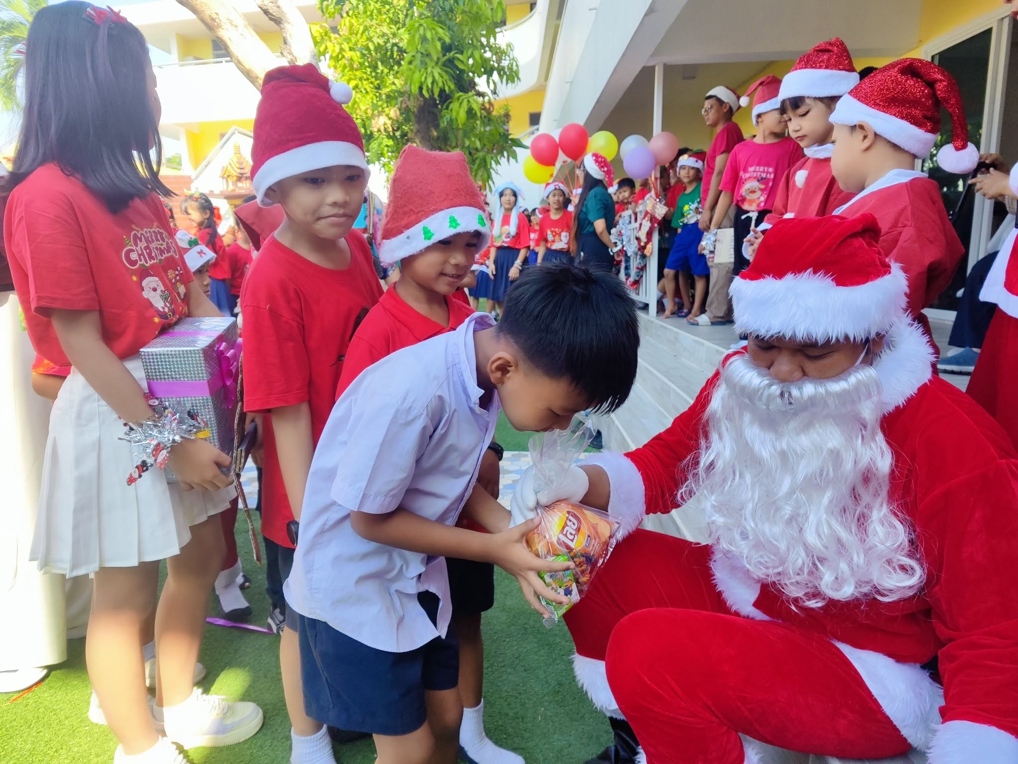 Kong Lah School students receiving gifts during a holiday event.