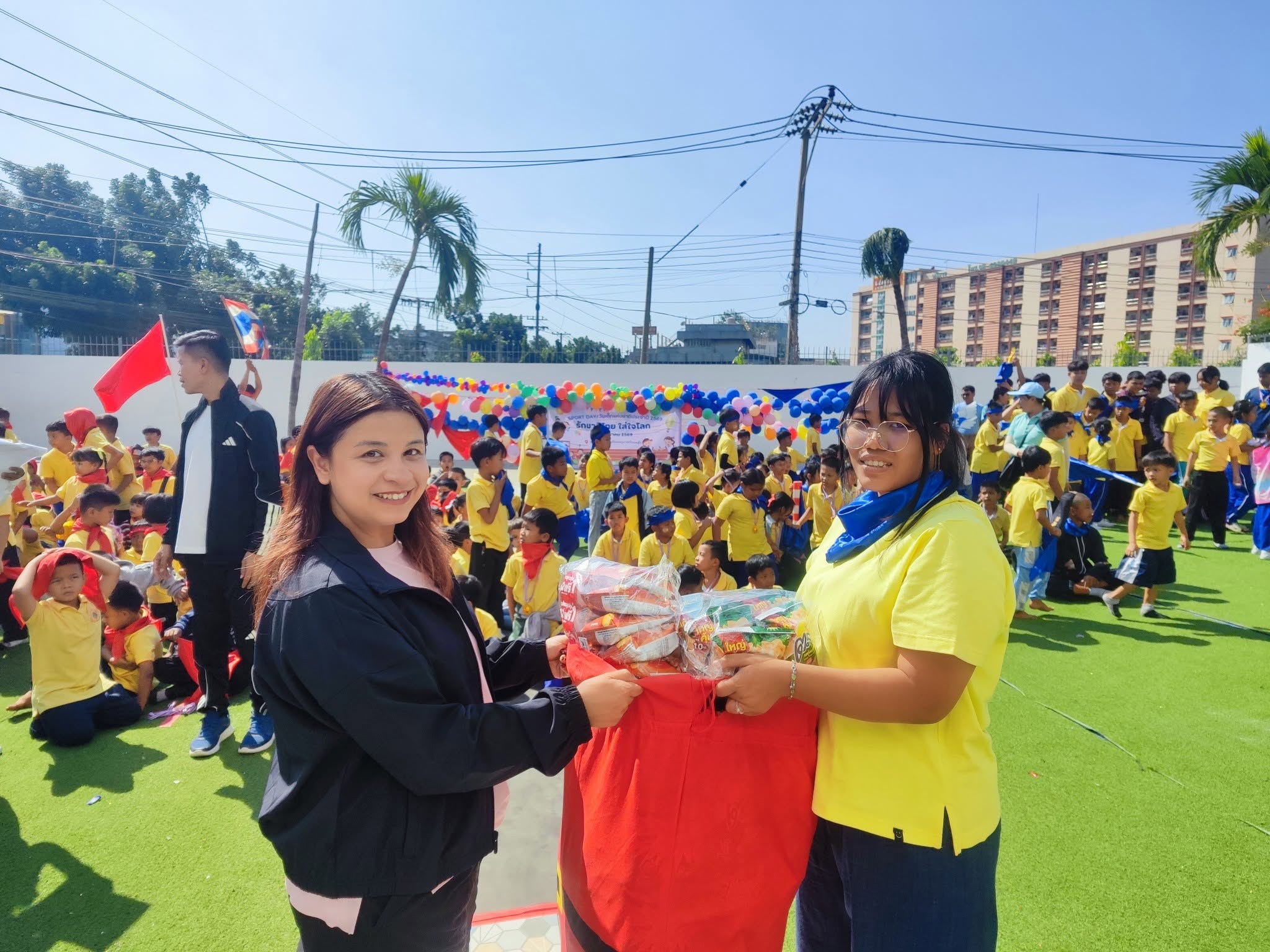 Kong Lah School teacher and student at a busy school celebration.