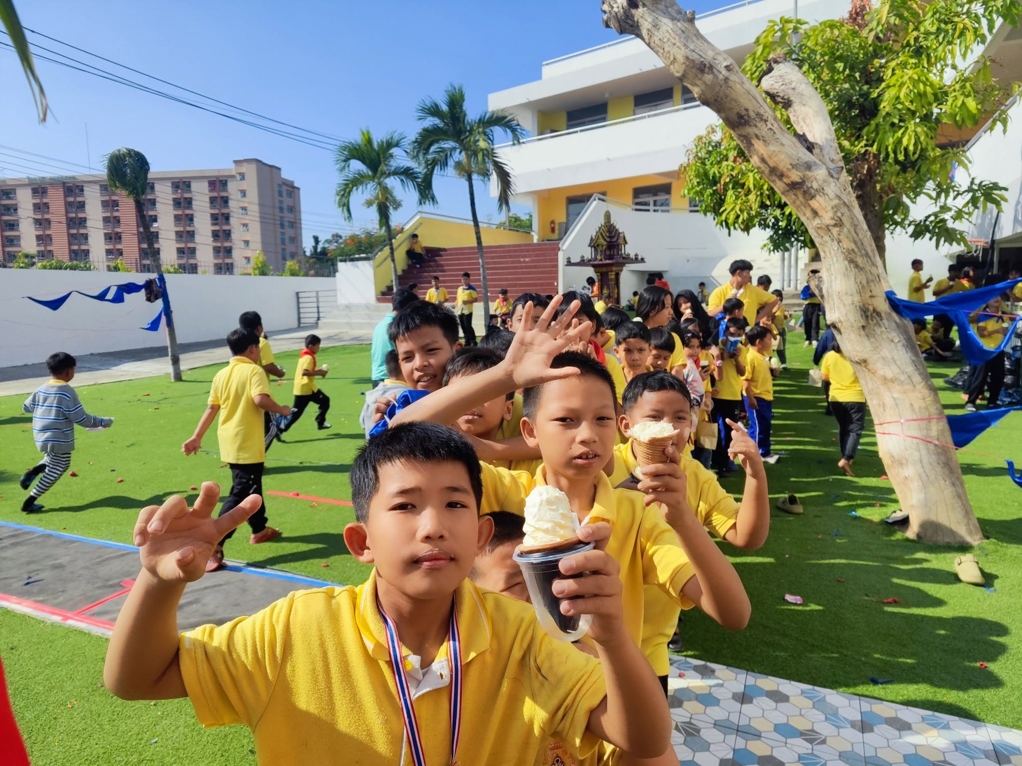 Kong Lah School children smiling outdoors during a school event.